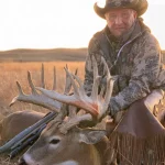 man hold hunted deer prize